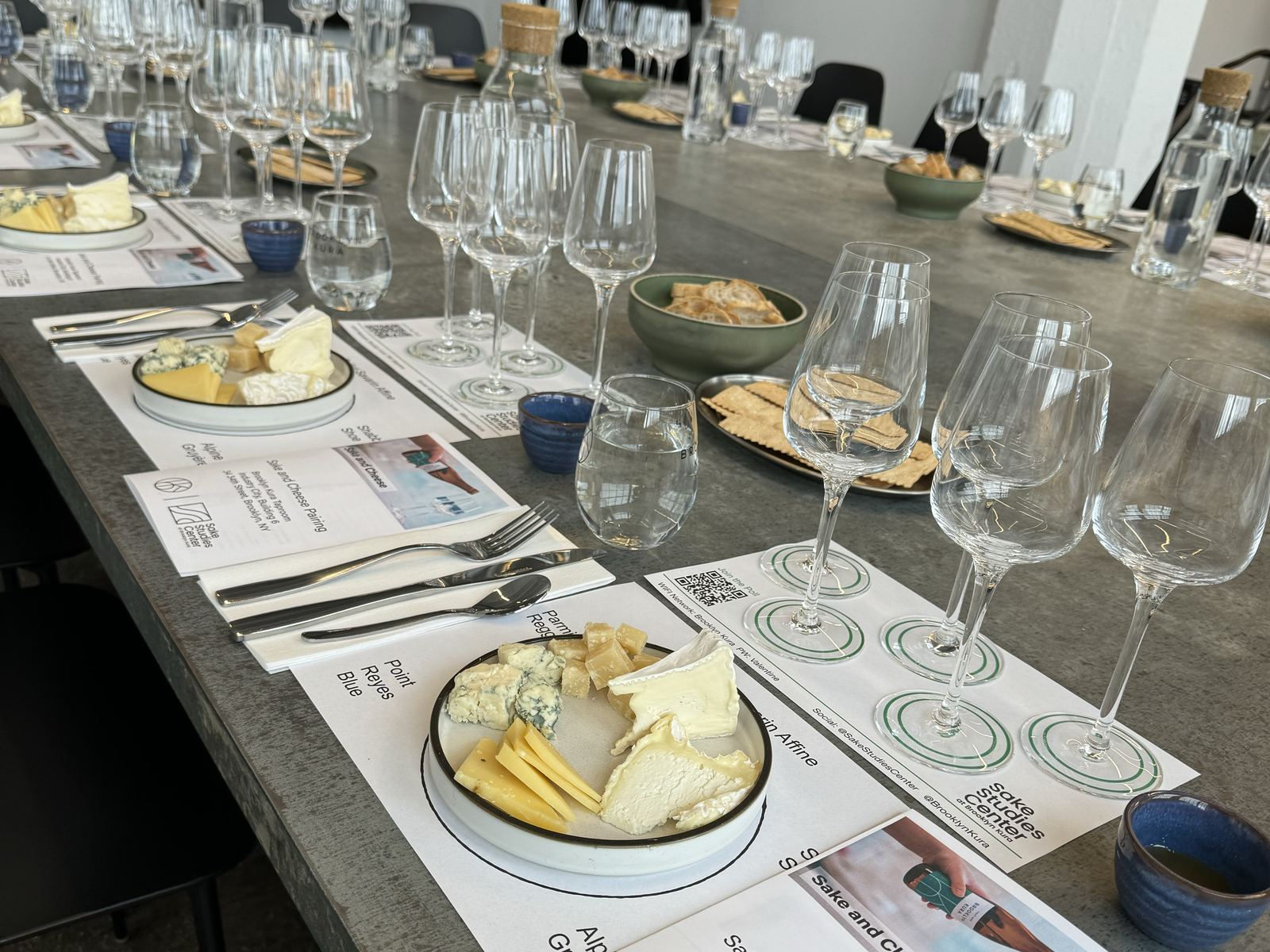 The long table set with cheese boards and tasting flights for the pairing class