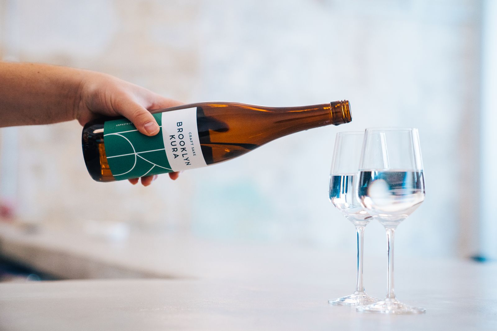 Pouring Brooklyn Kura sake into tasting glasses