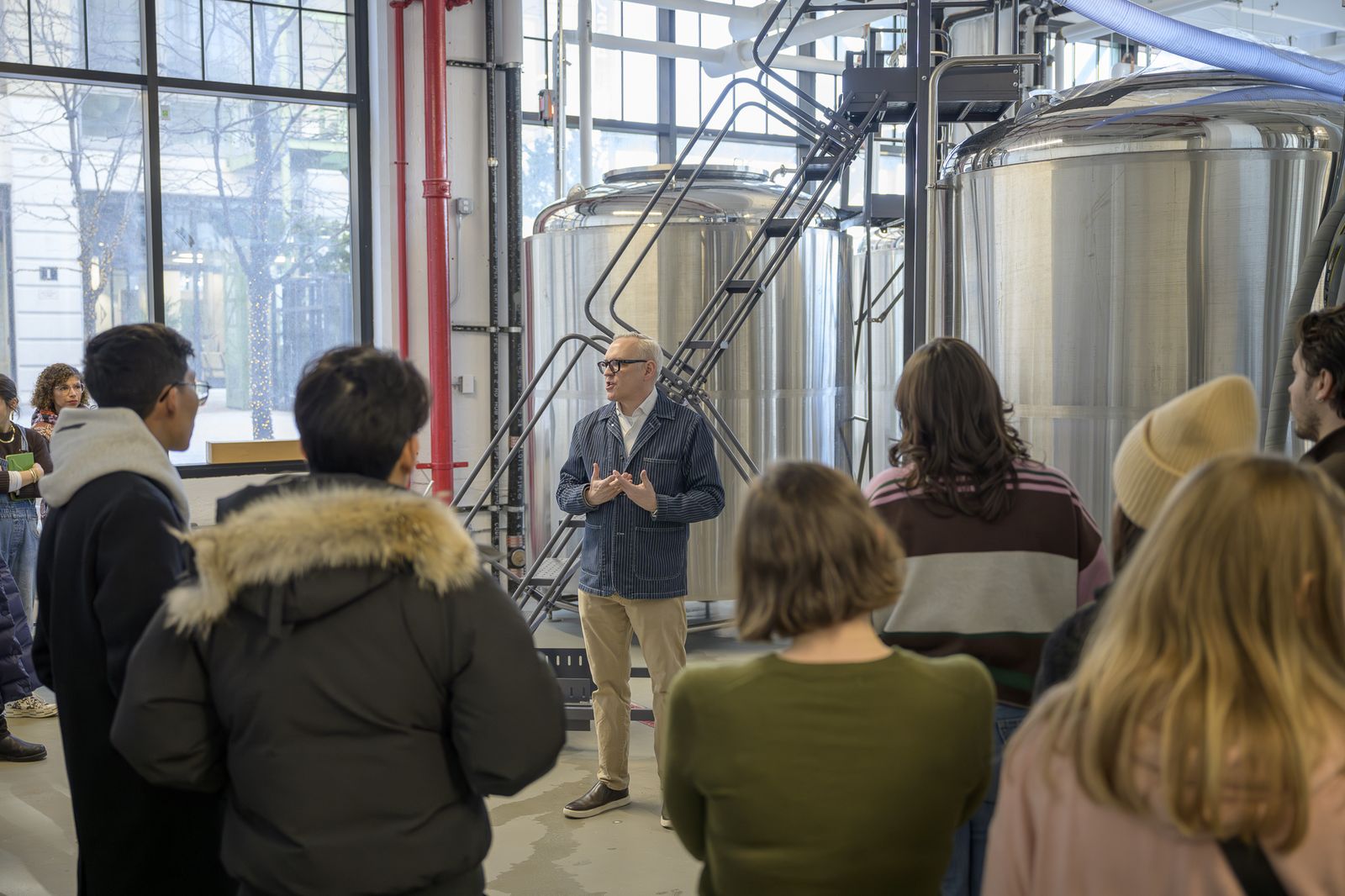 Timothy Sullivan teaching the Sake Server Certification class beside the brewing tanks