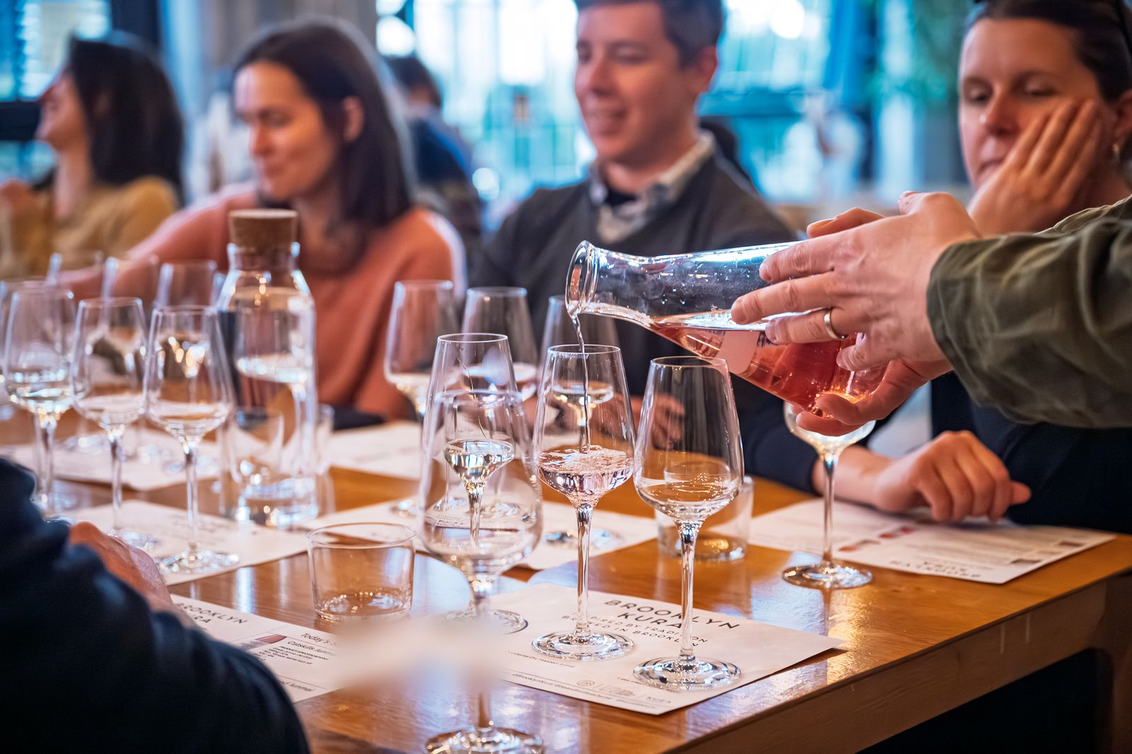 Pouring sake for guests at the tasting table after a brewery tour