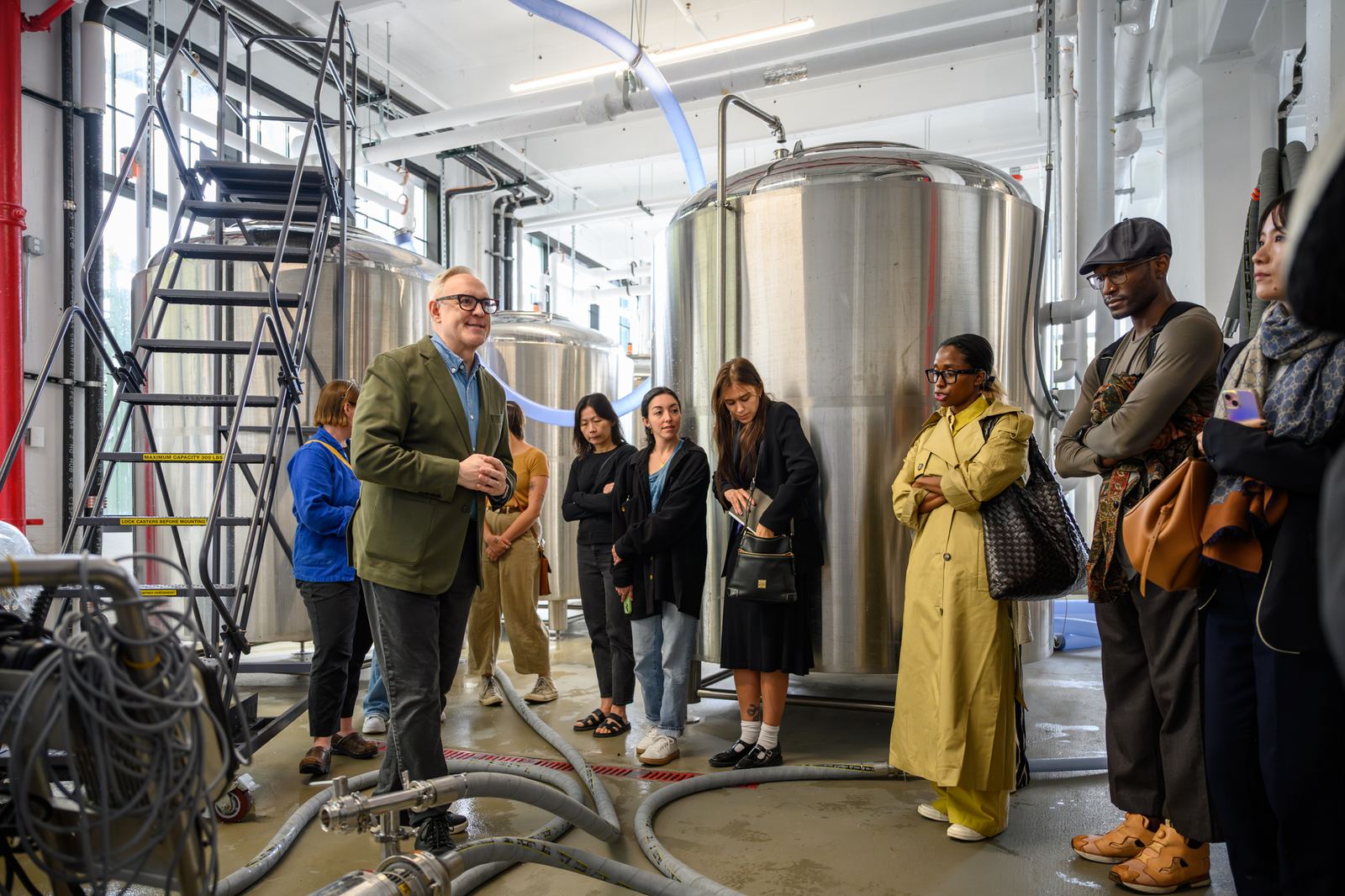 Guests on the brewery floor among the tanks during the tour at a previous Sake for Wine Somms luncheon